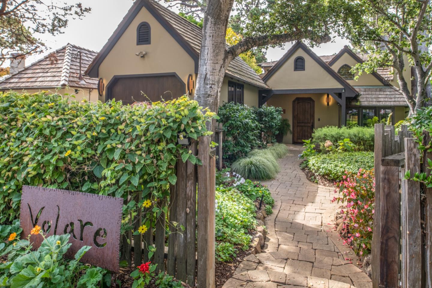 a front view of a house with a yard and potted plants