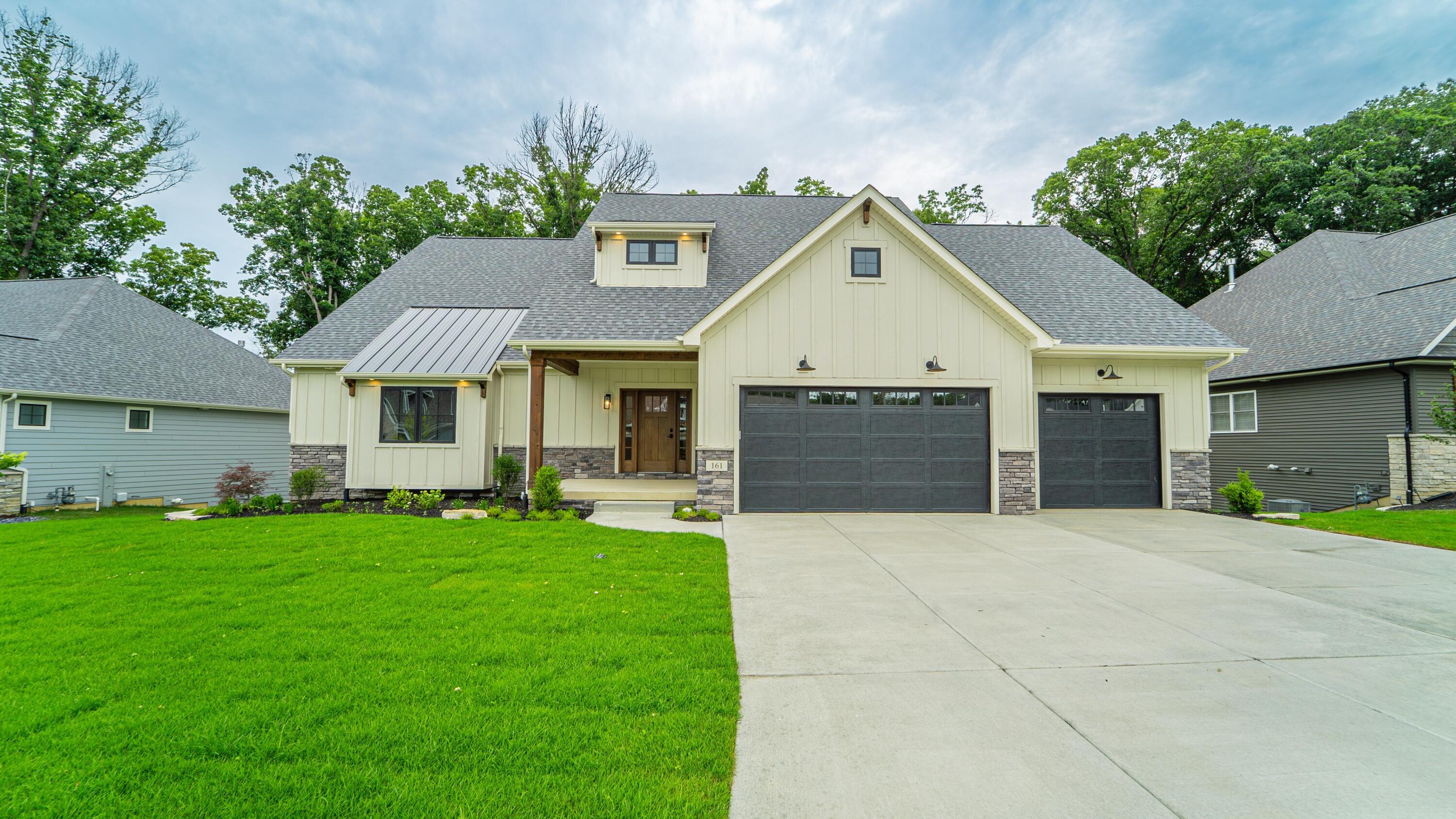 a front view of a house with a garden and yard