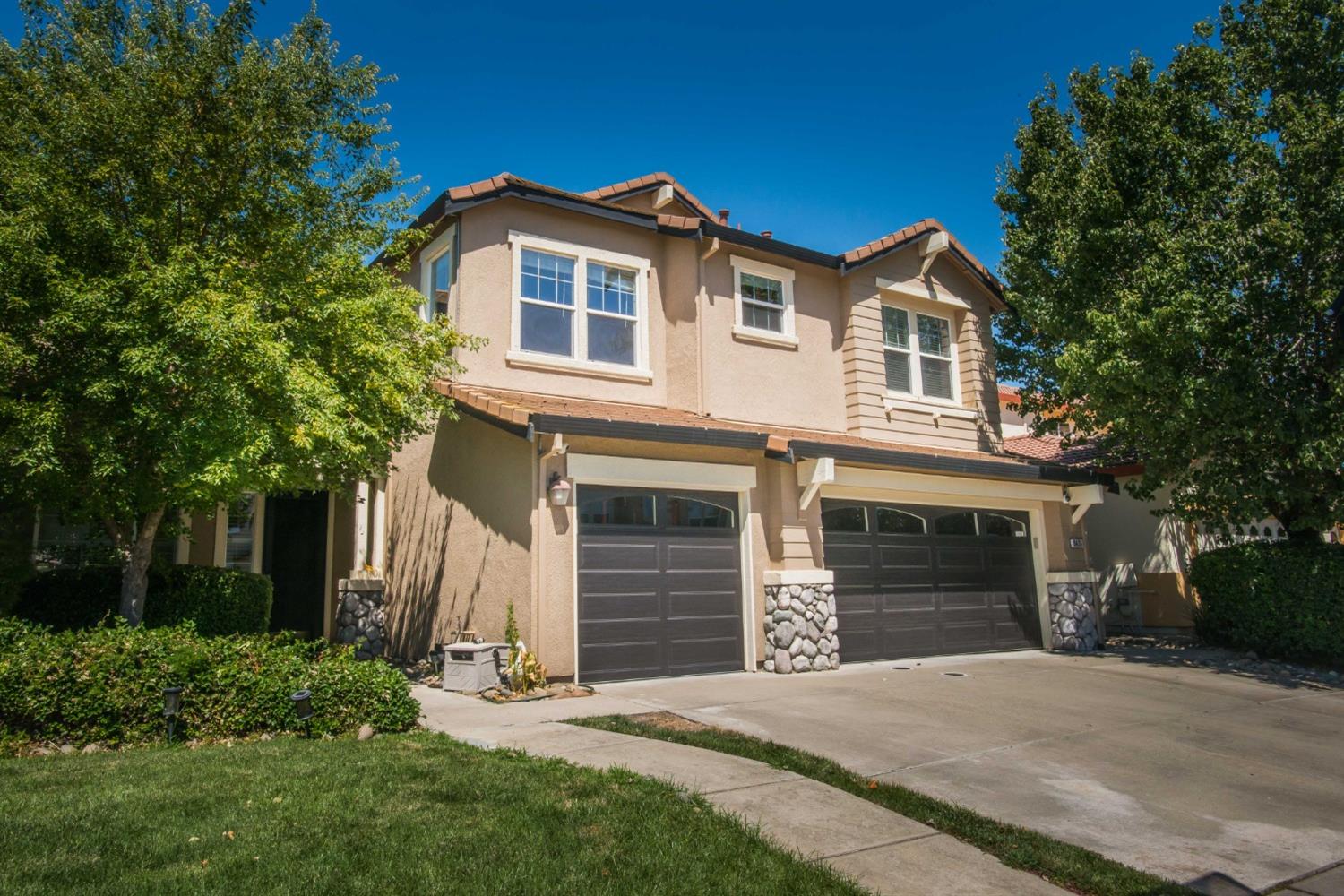 a front view of a house with a yard and garage