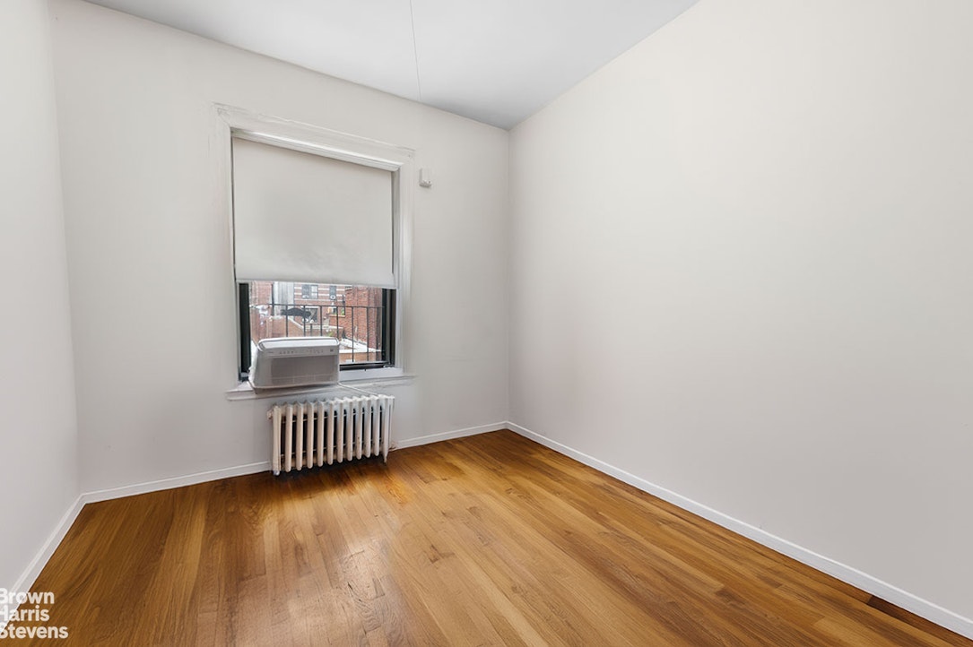 a view of a room with wooden floor and a window