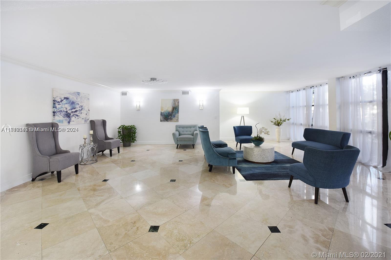 a living room with furniture and a dining table with kitchen appliances