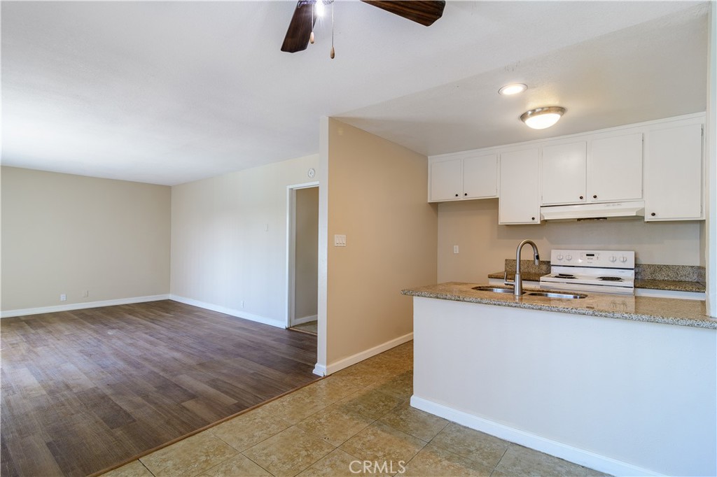 a kitchen with stainless steel appliances granite countertop a sink a stove top oven a counter space and cabinets