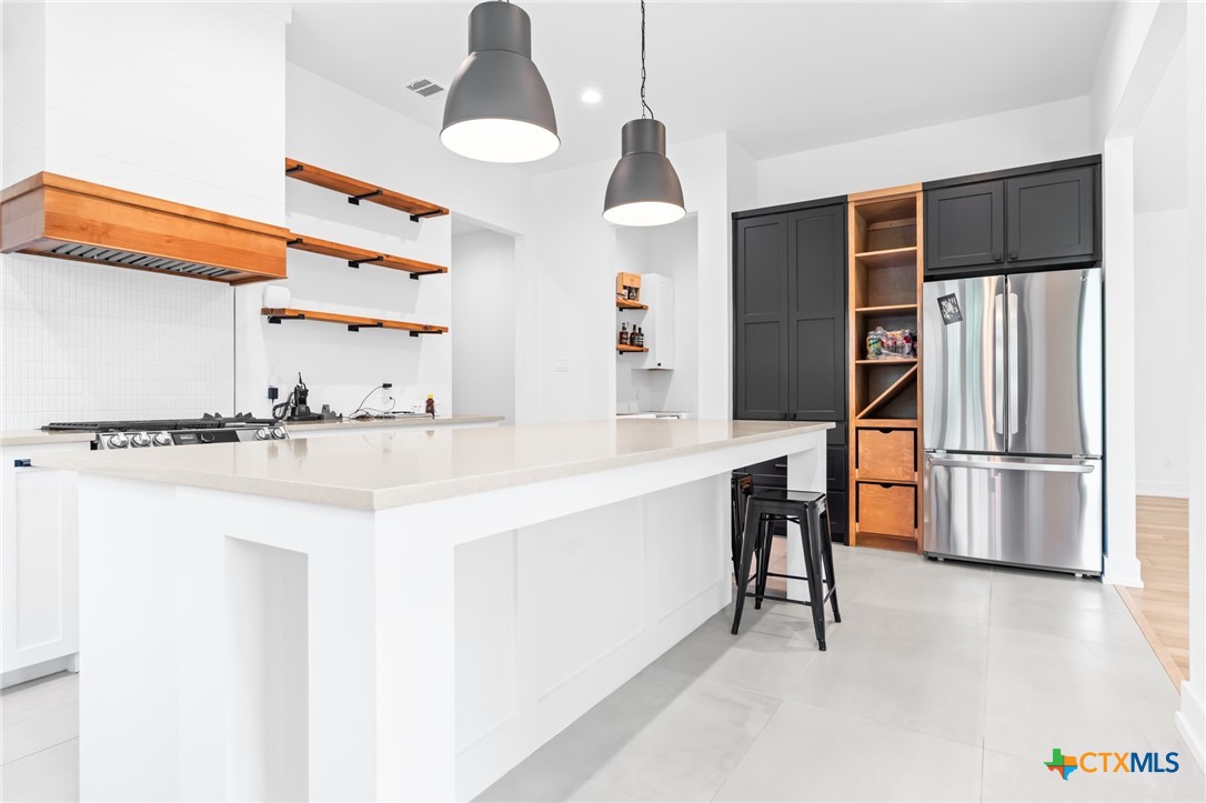 a kitchen with stainless steel appliances a sink and a refrigerator