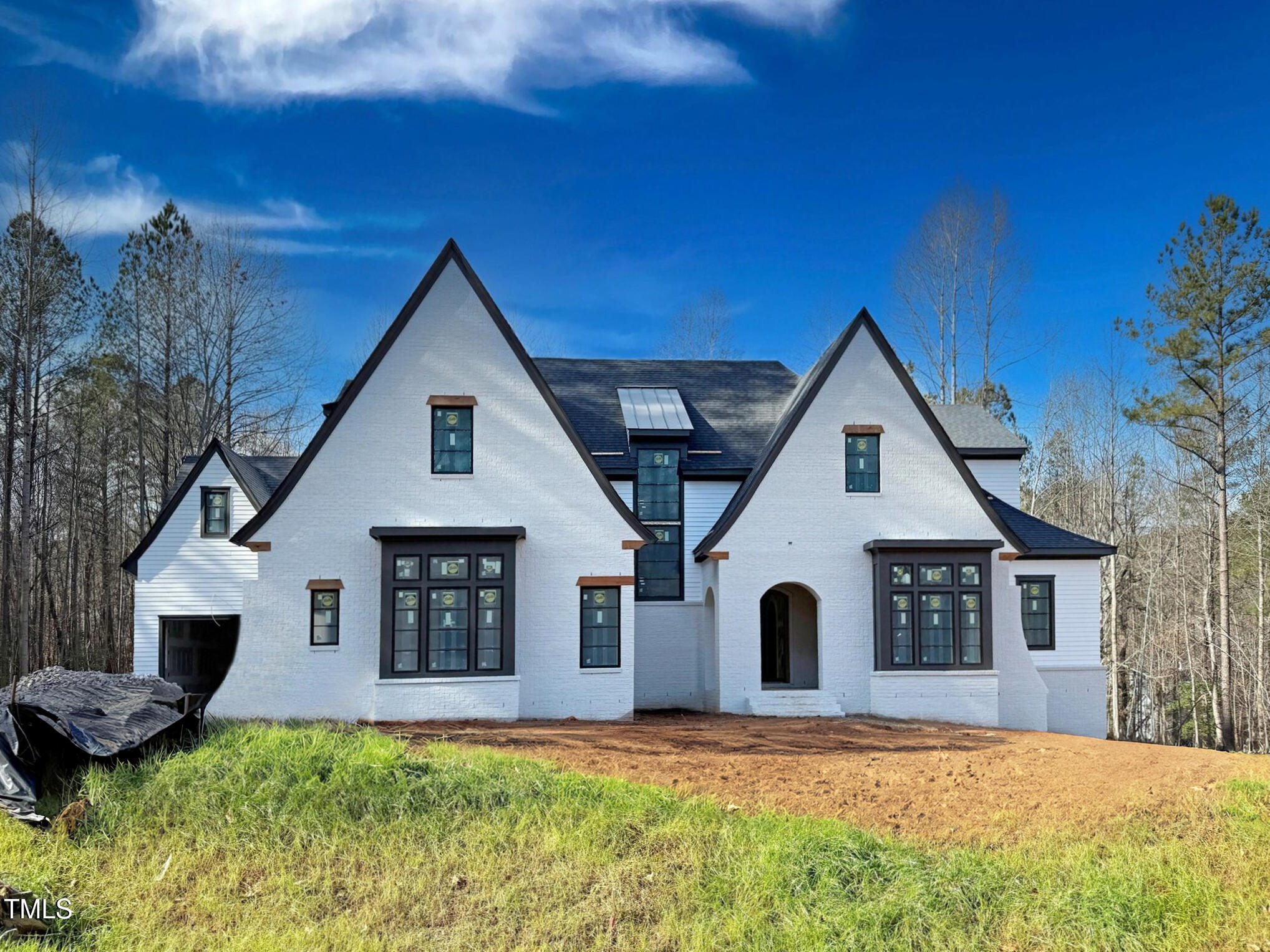 a front view of house with yard and trees in the background