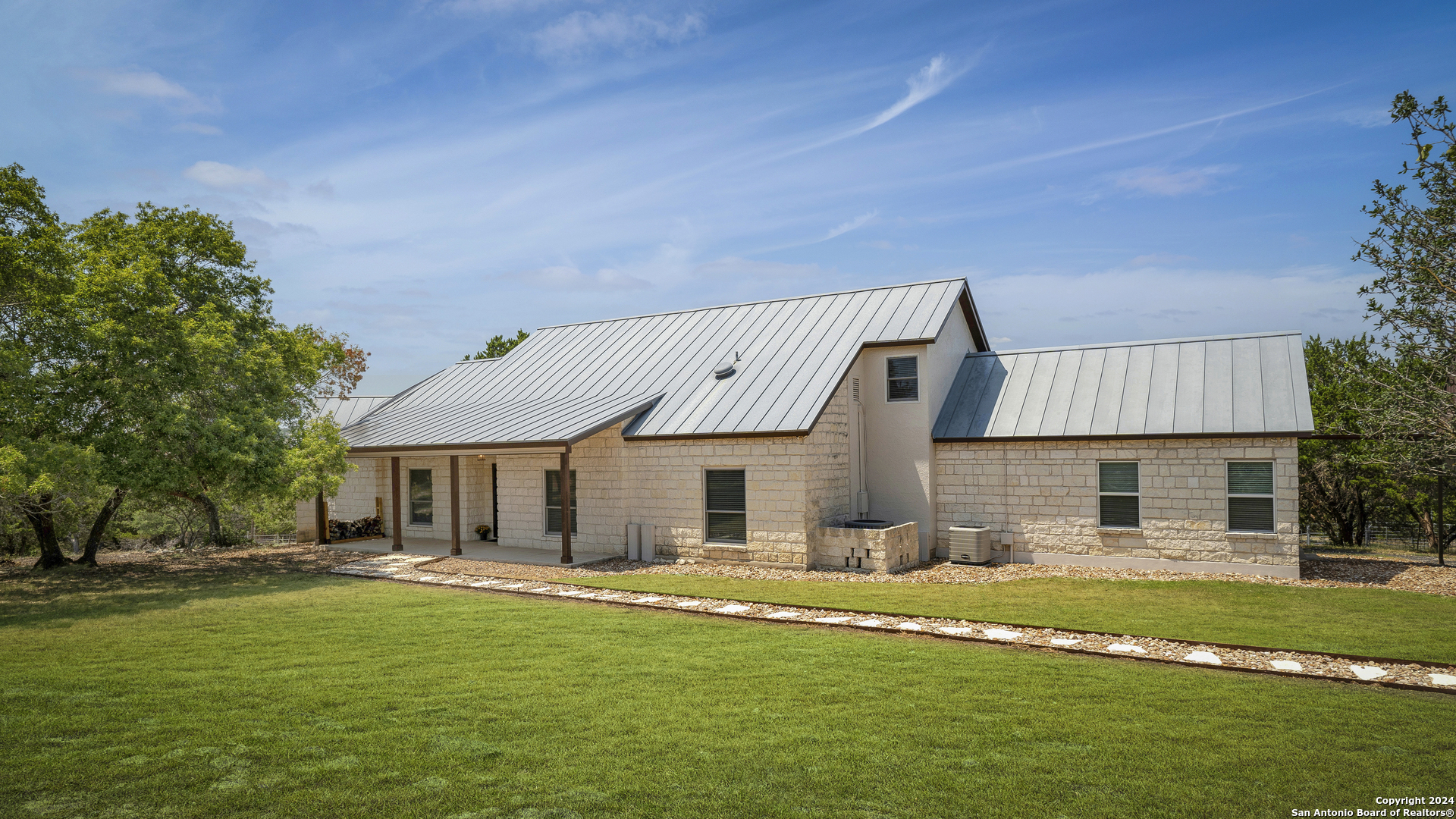 a front view of a house with a garden and sitting area