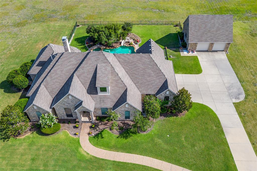 an aerial view of a house with swimming pool garden and lake view