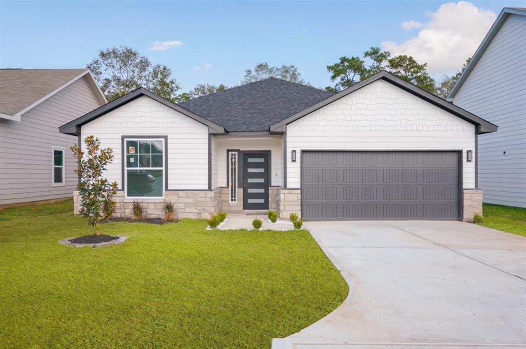 a front view of house with yard and trees in the background