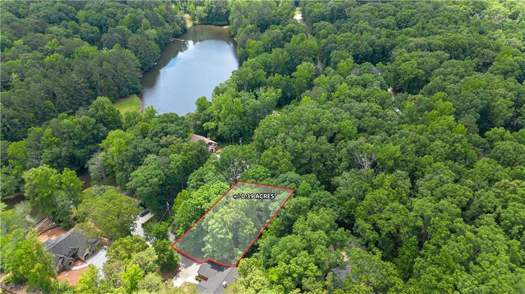 an aerial view of residential house with outdoor space and trees all around