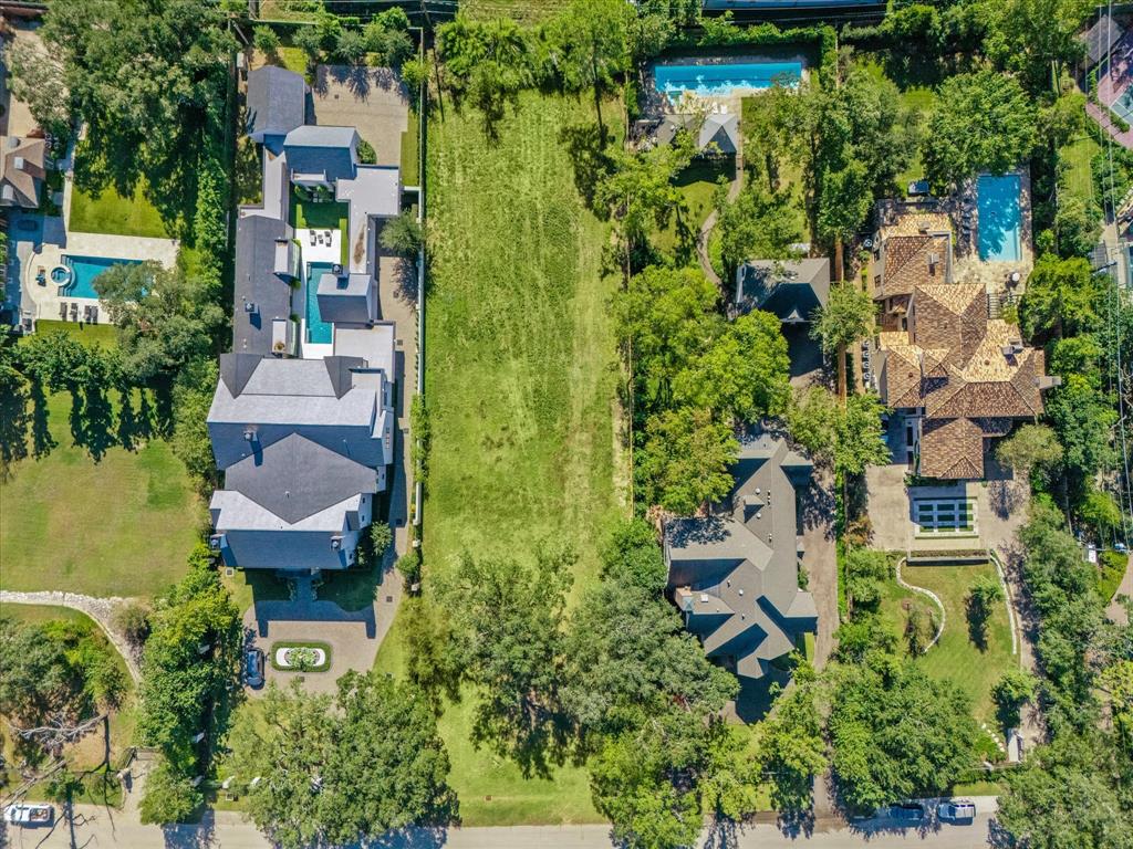 an aerial view of residential houses with outdoor space and trees