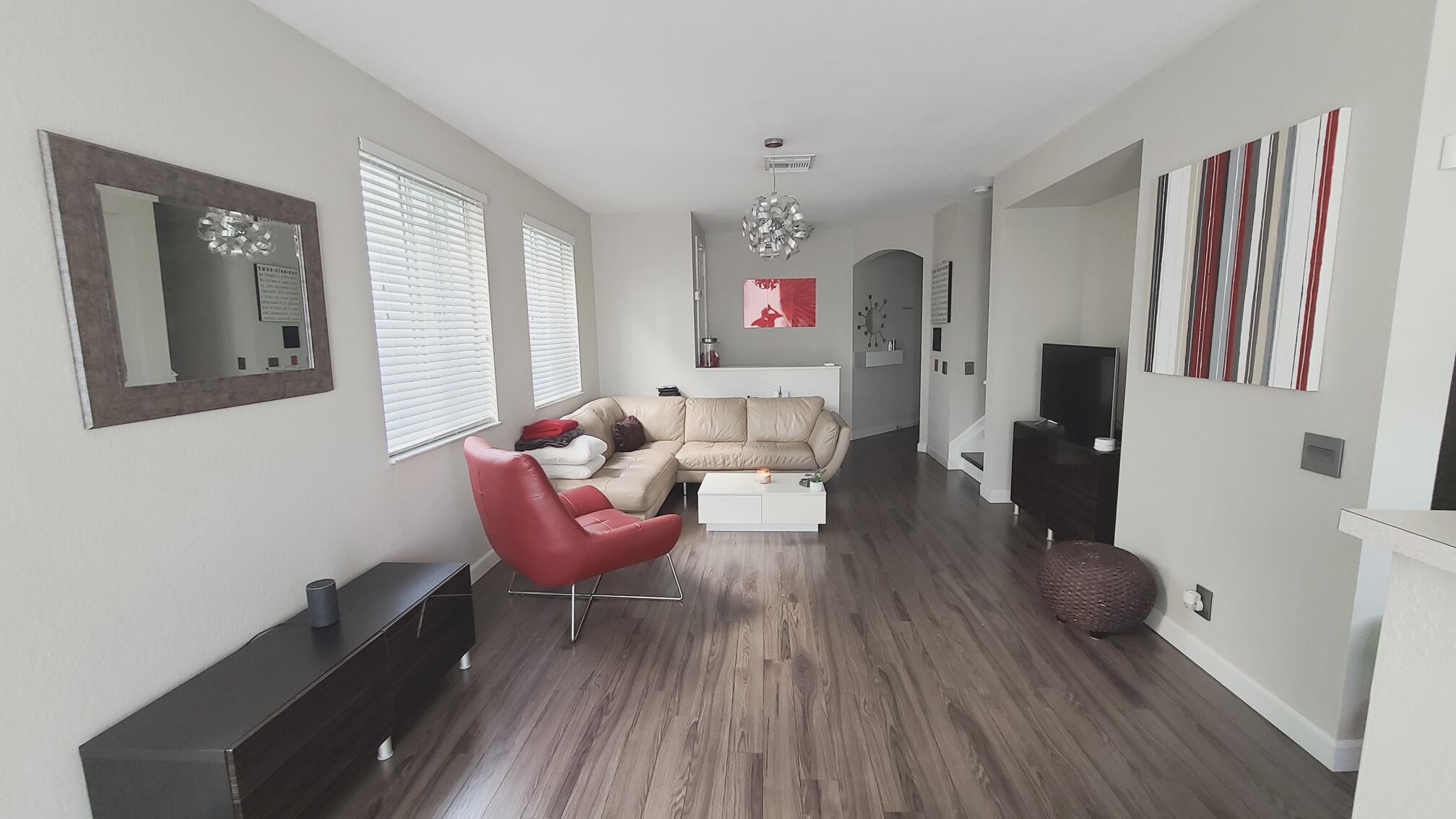 a living room with furniture and a wooden floor