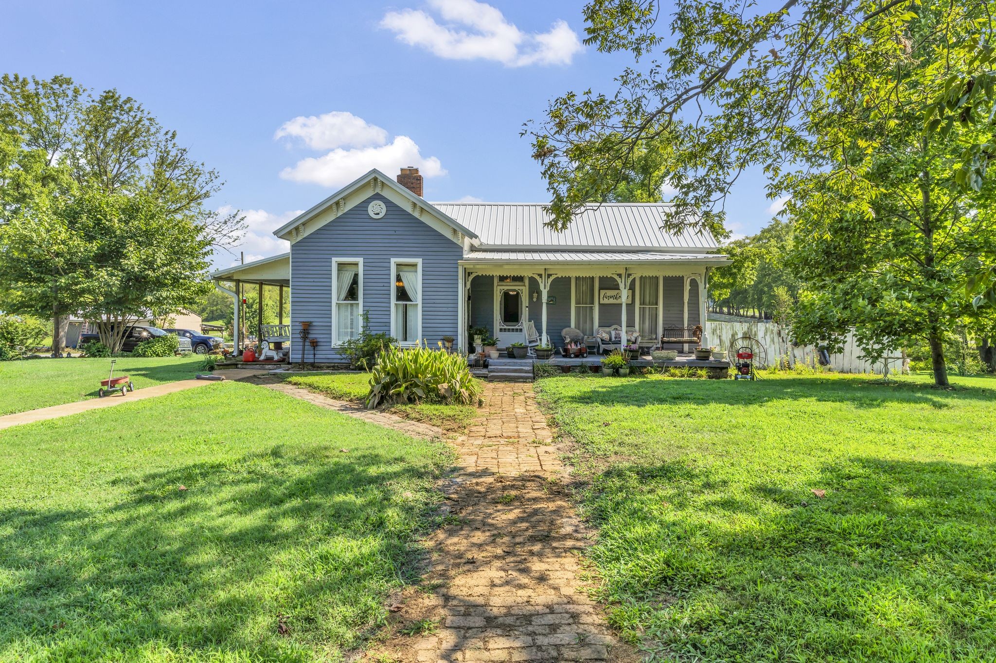 a front view of a house with a garden and trees