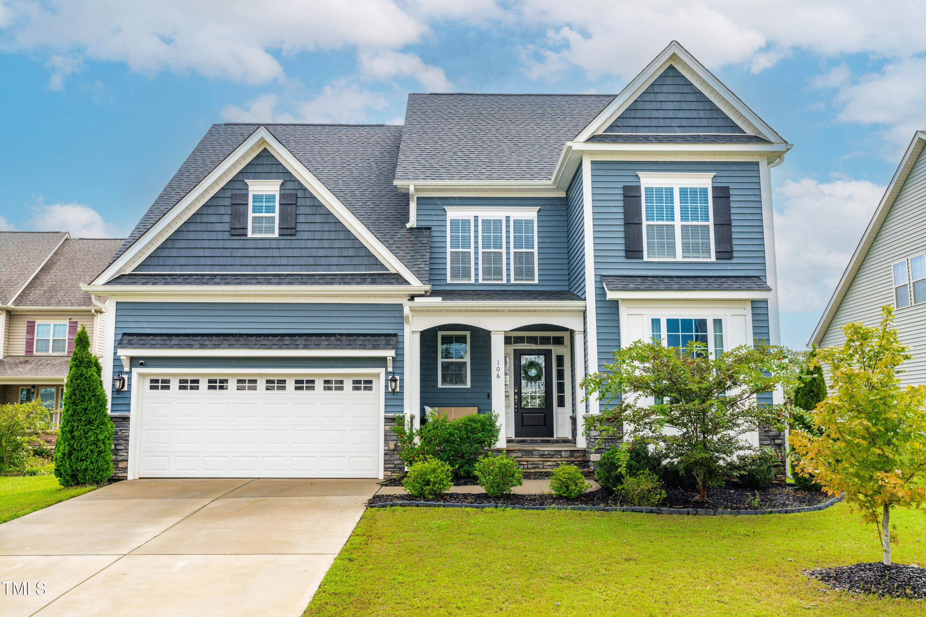 a front view of a house with a yard and garage