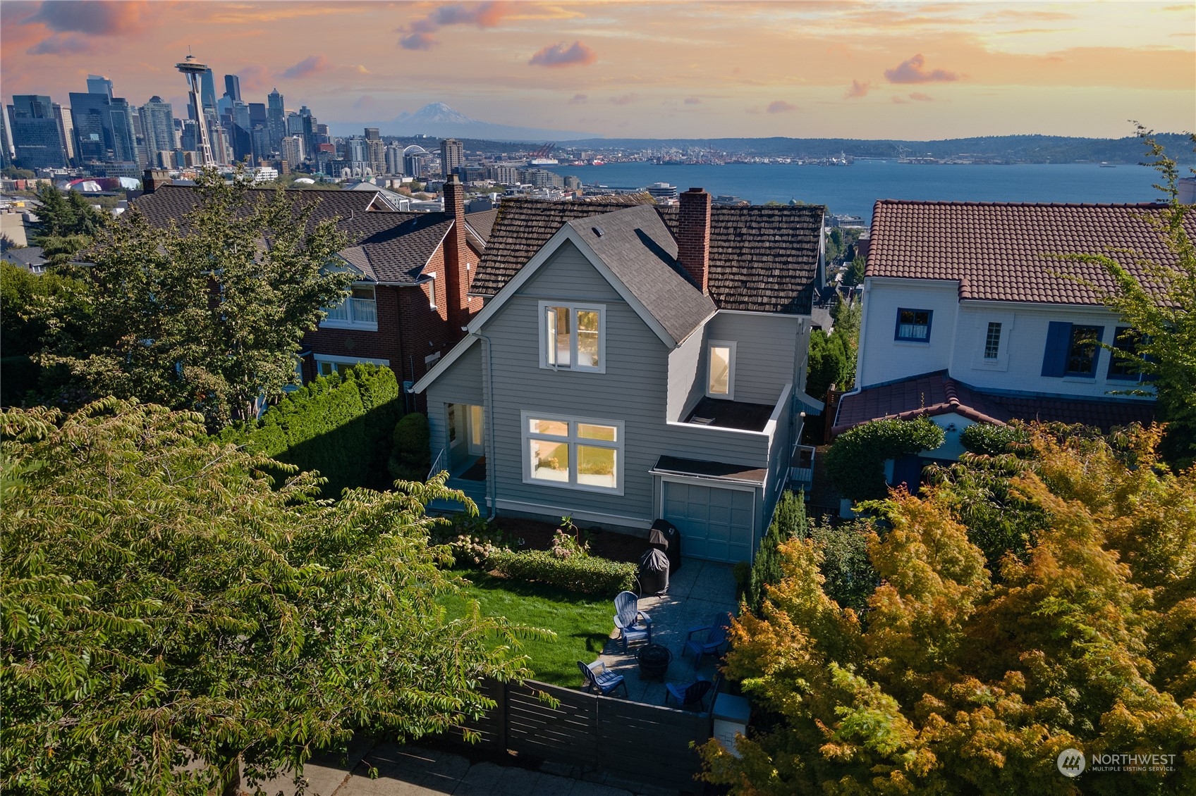 an aerial view of a house with a yard and a large tree