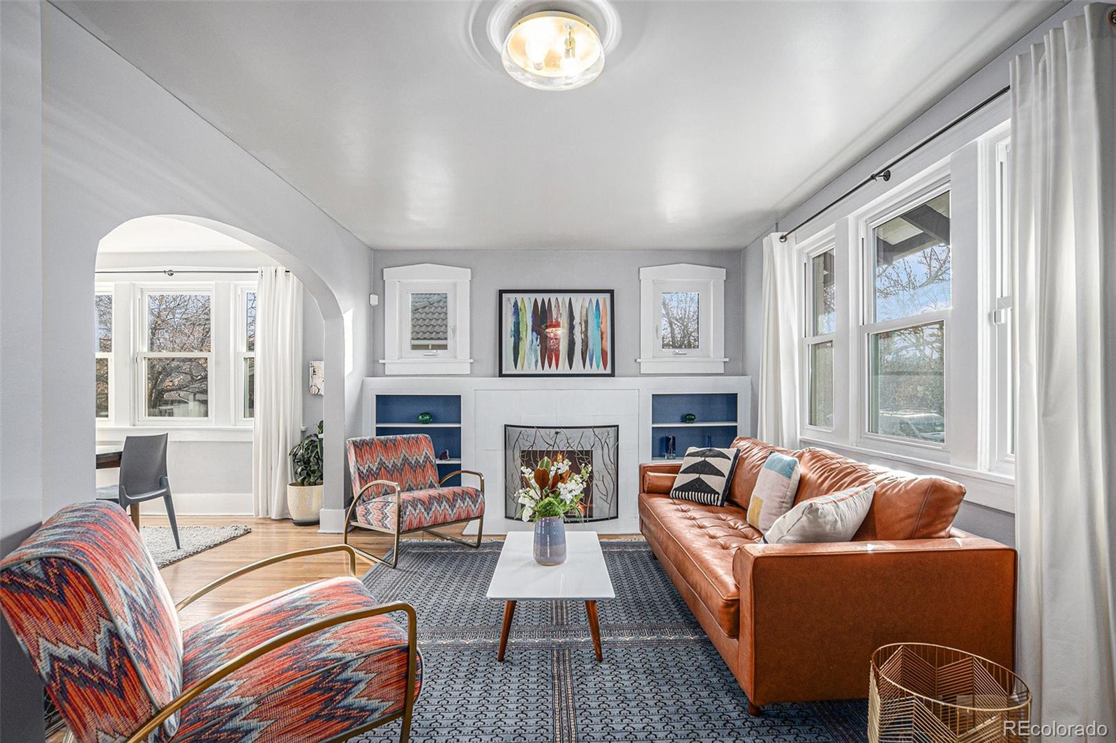 a living room with fireplace furniture and a large window