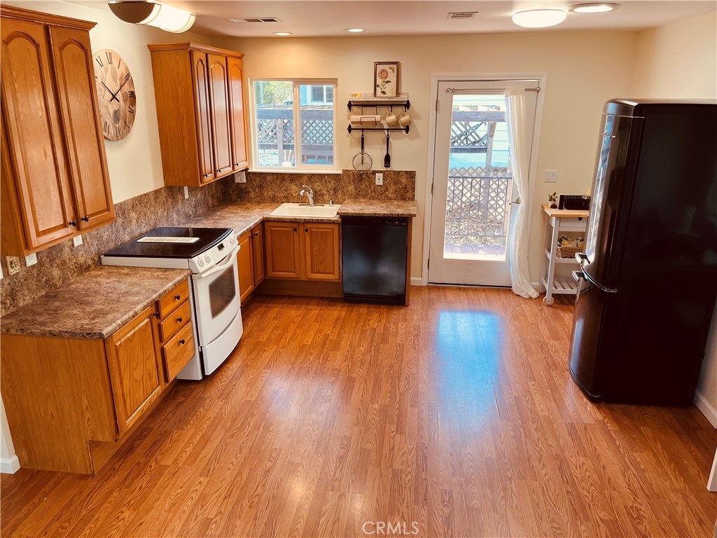 a kitchen with stainless steel appliances granite countertop wooden floors and sink