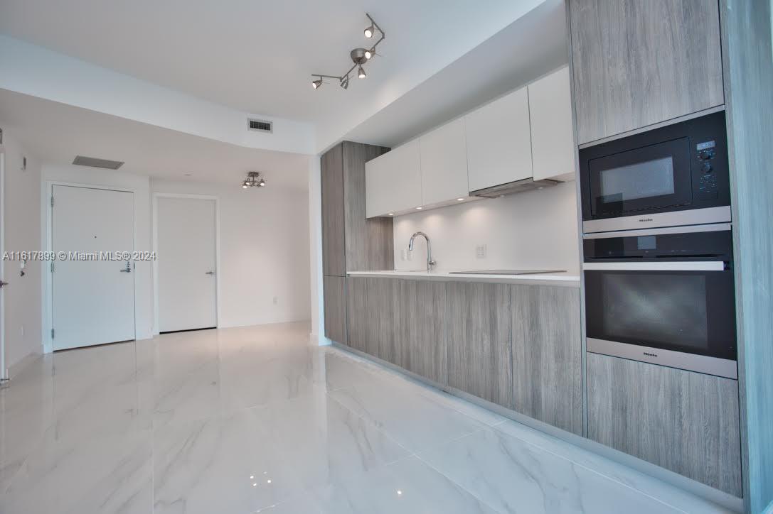 a view of an empty room with a kitchen