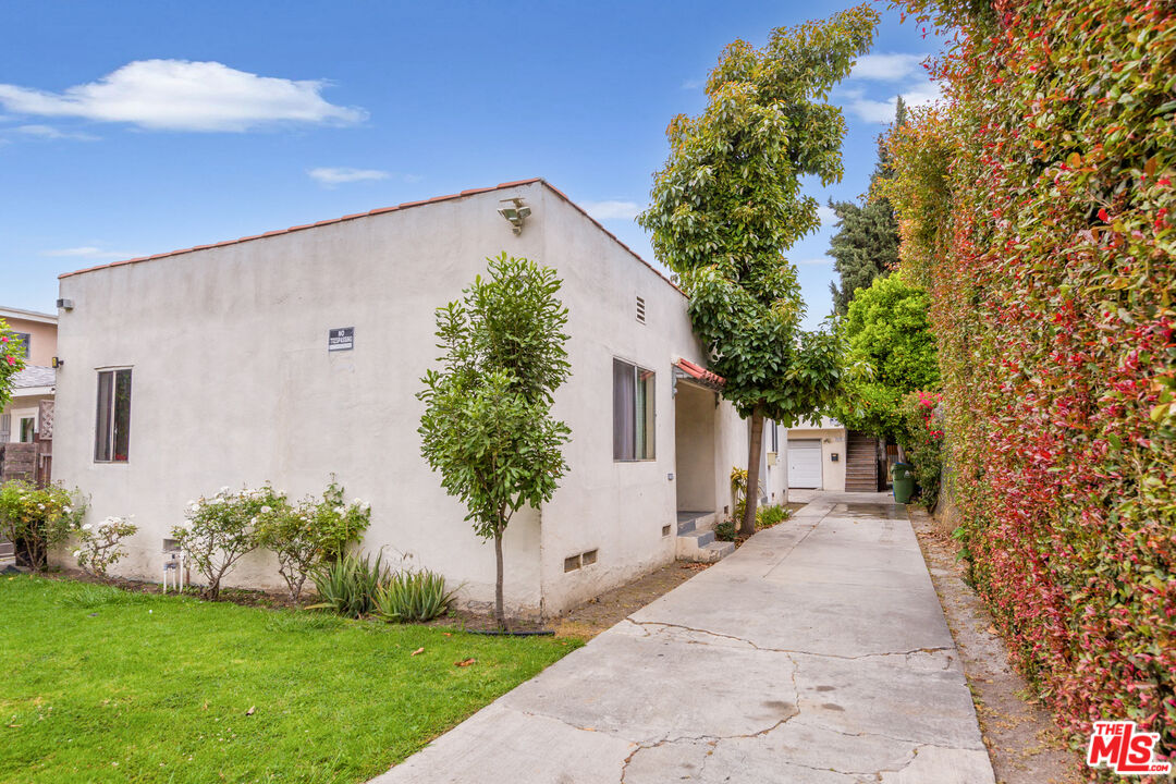 a front view of a house with a yard and trees