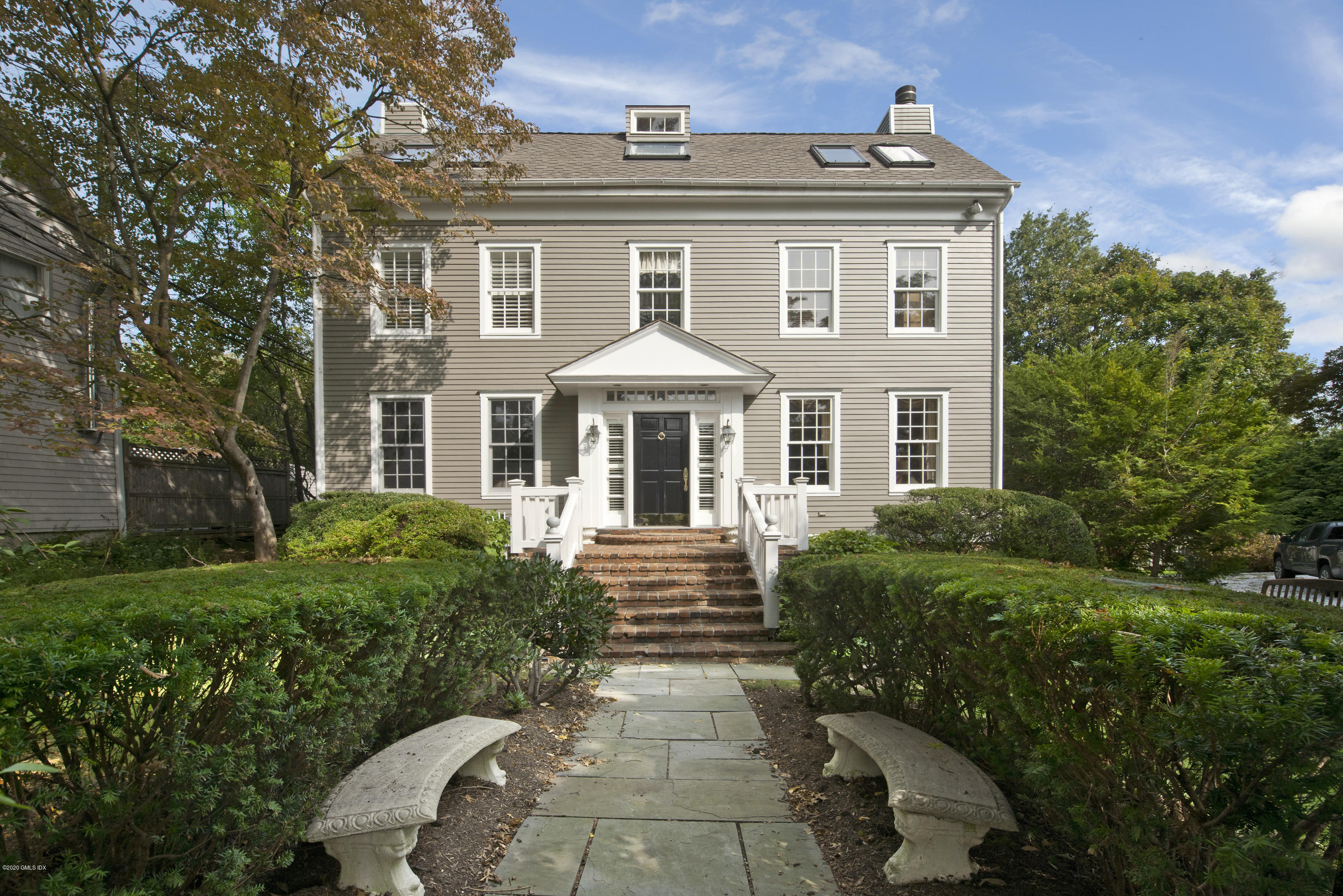 a front view of a house with yard and green space