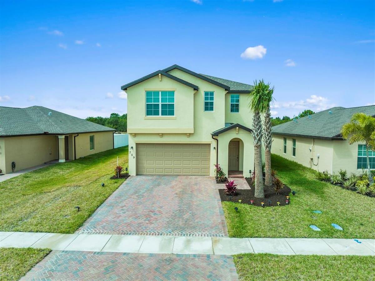 a front view of a house with a yard and garage