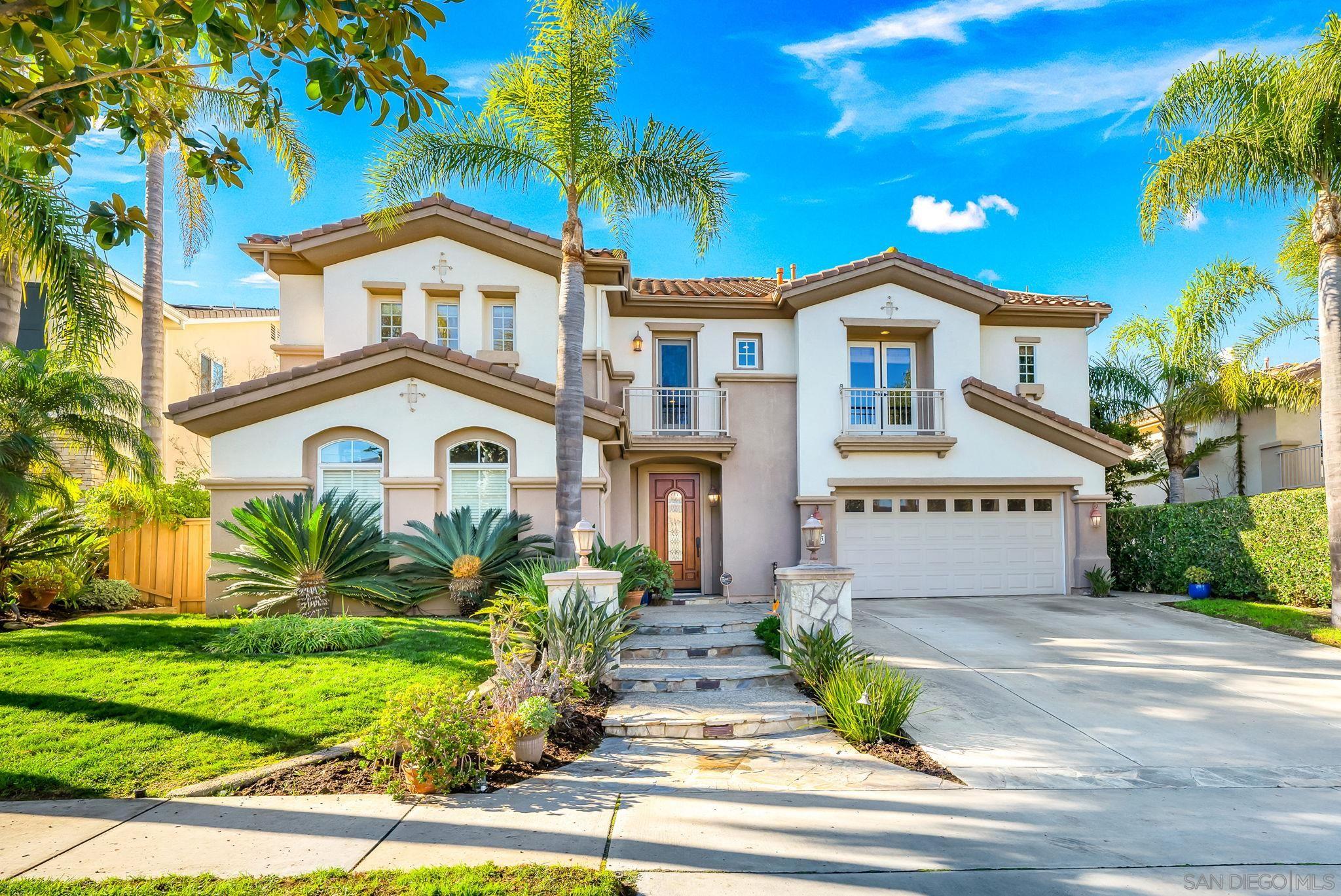 a front view of a house with a yard and potted plants