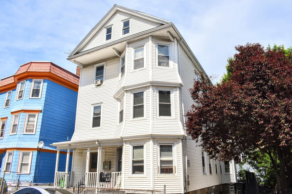 a front view of a house with a tree