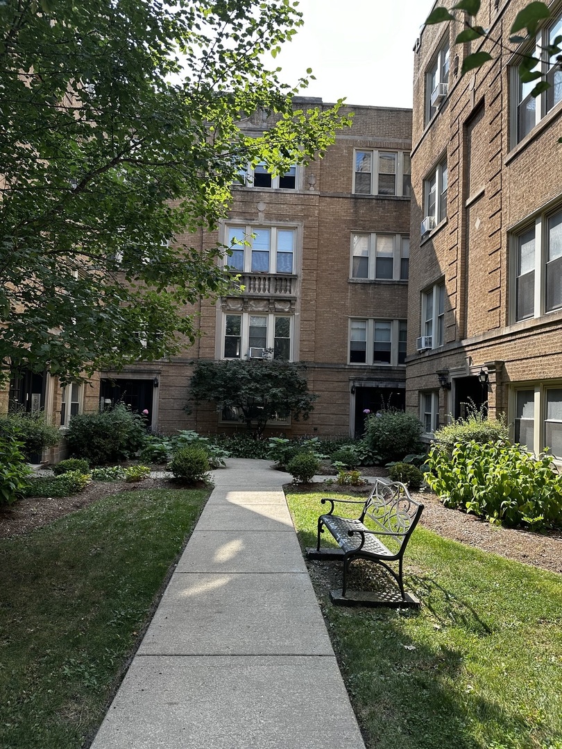 a view of a chair and table in backyard of the house