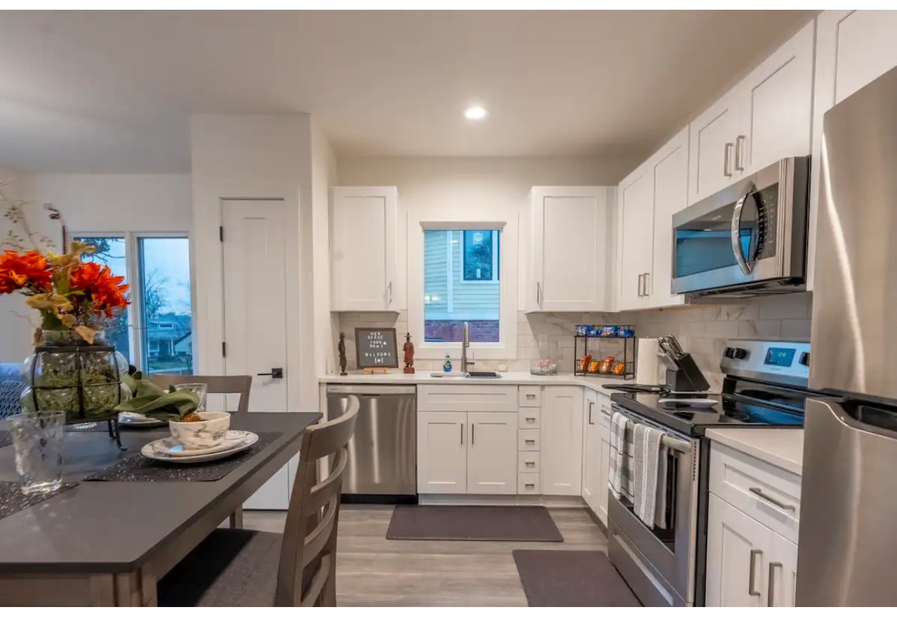 a kitchen with stainless steel appliances kitchen island granite countertop a sink dishwasher stove and cabinets