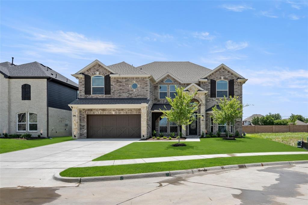 a front view of a house with a yard and trees