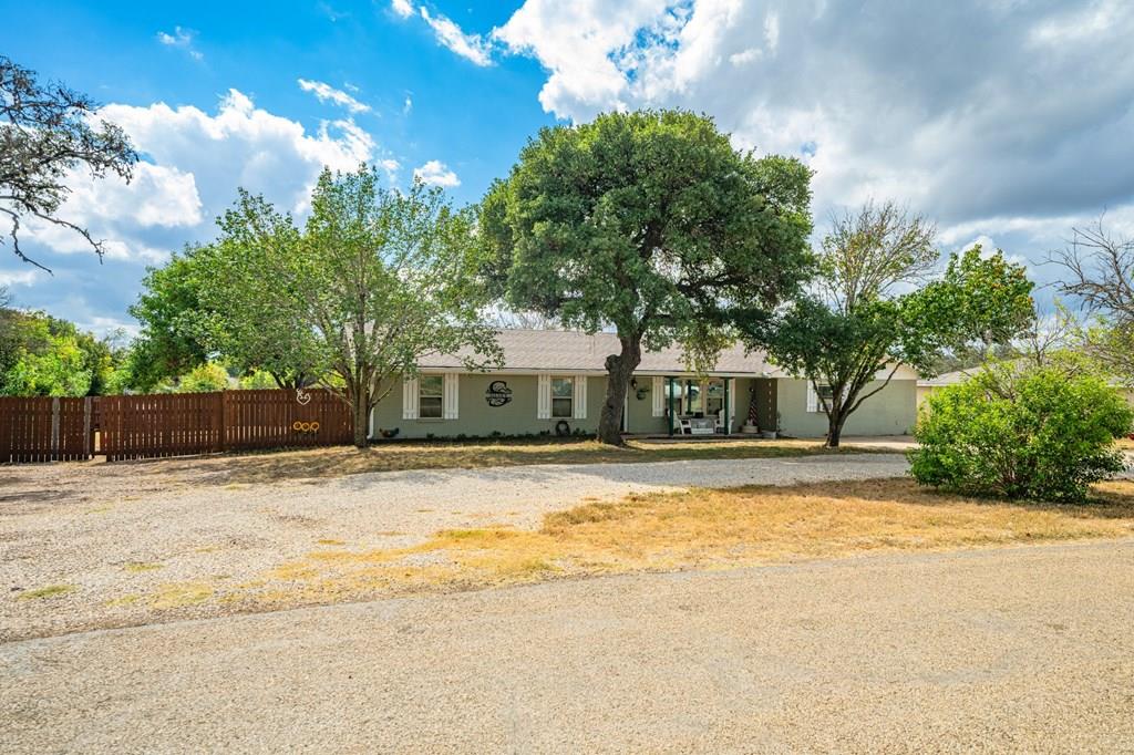 a front view of a house with a yard and trees