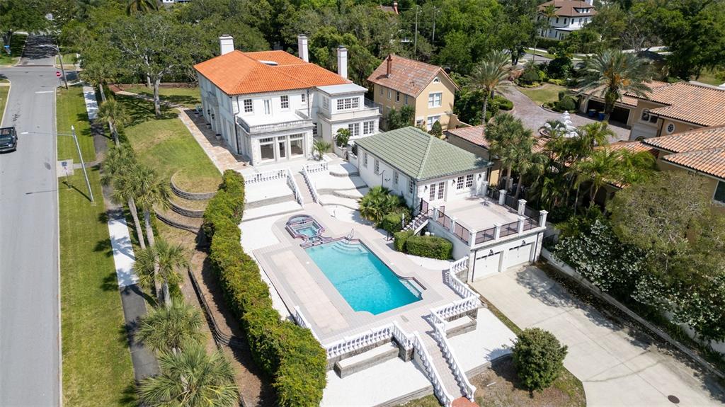 an aerial view of a house with swimming pool and outdoor seating