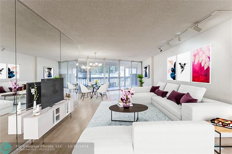 a living room with furniture kitchen view and a large window