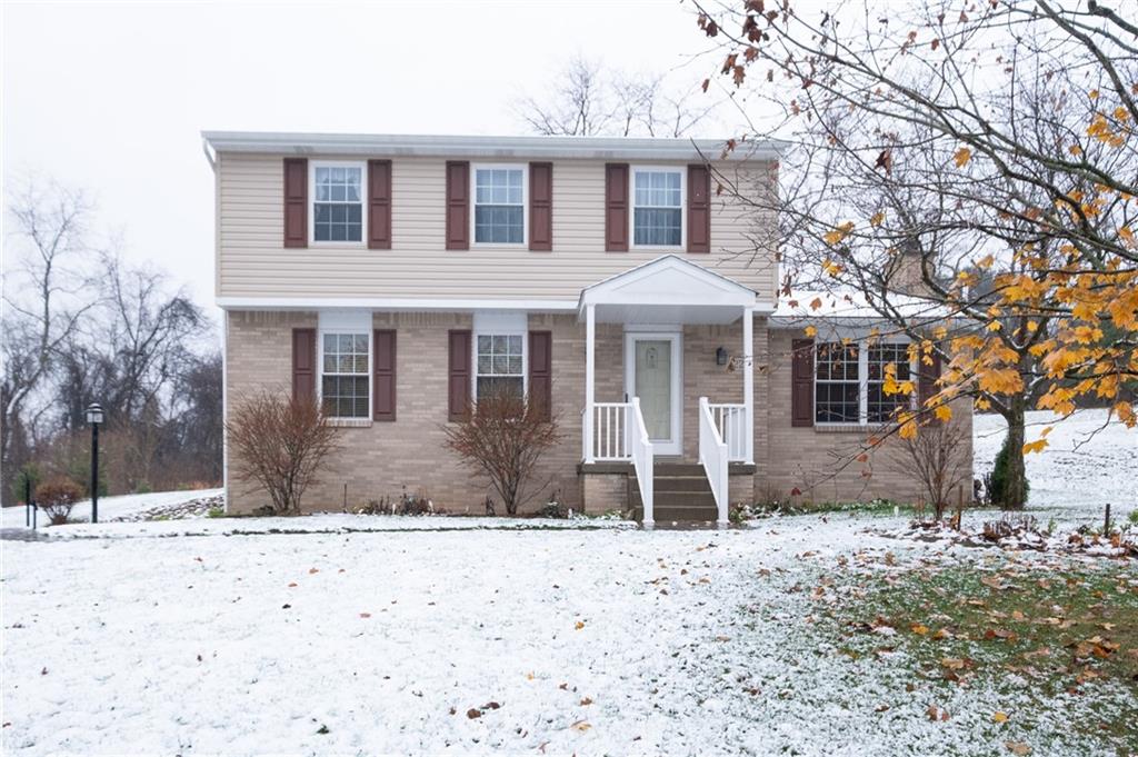 a front view of a house with a yard covered with snow