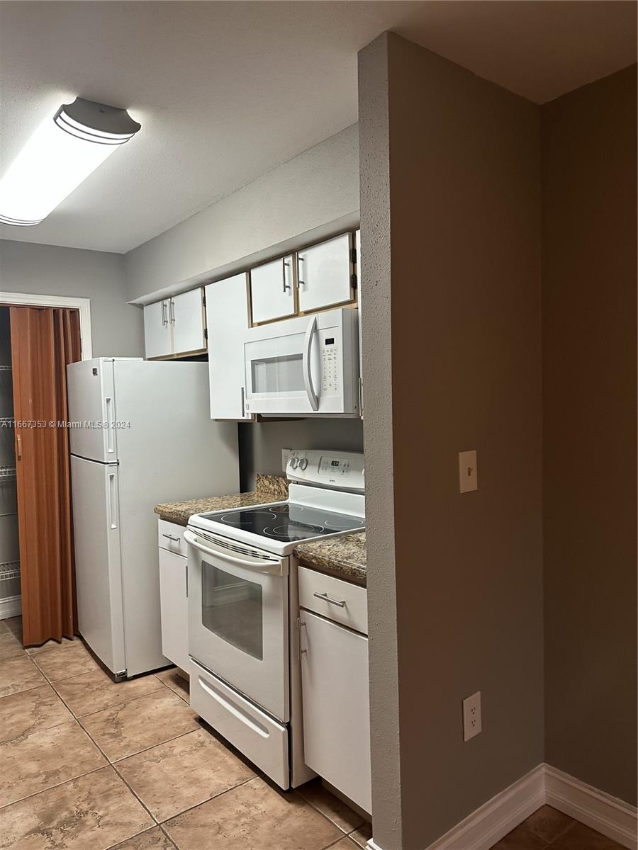 a kitchen with a stove top oven and refrigerator