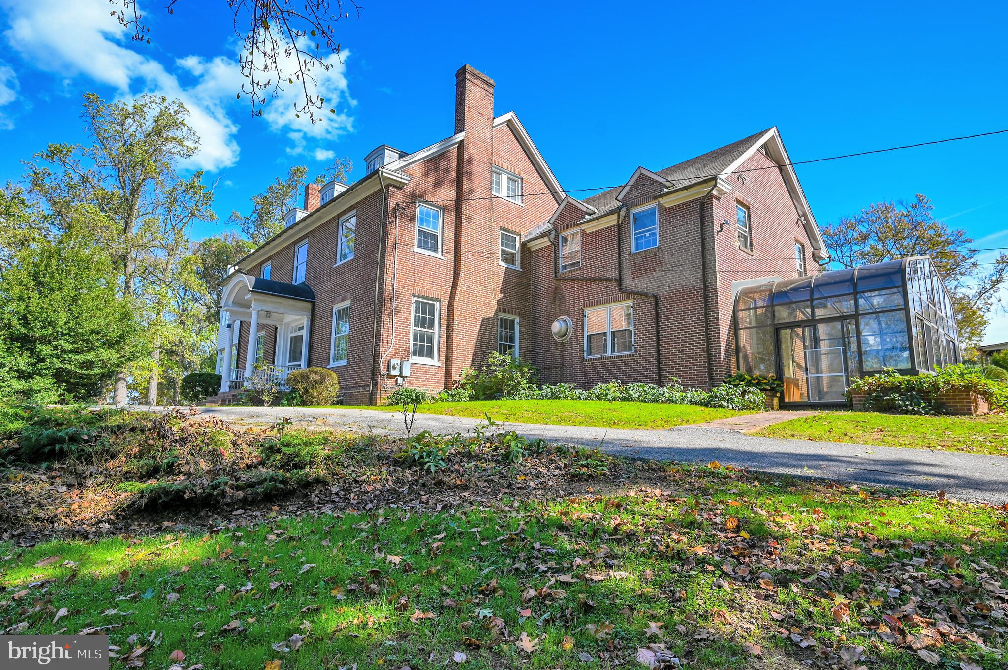 a front view of a house with a yard and trees