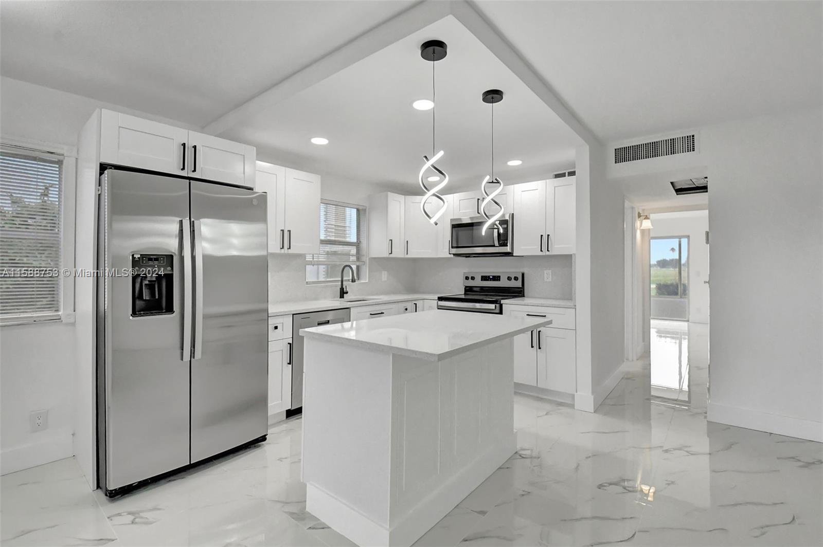 a kitchen with kitchen island a refrigerator sink and cabinets