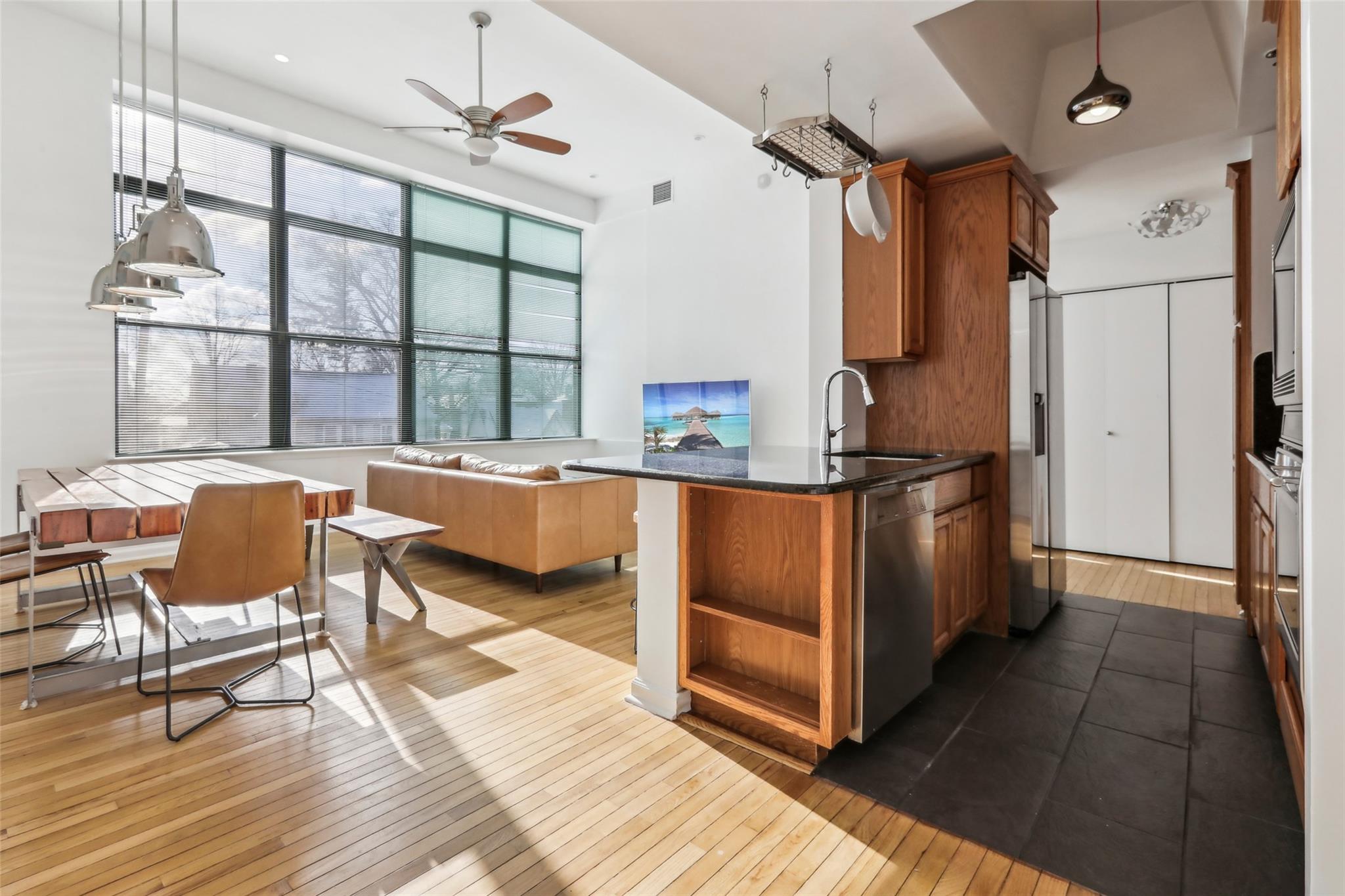 a kitchen with stainless steel appliances kitchen island granite countertop a refrigerator and a stove top oven