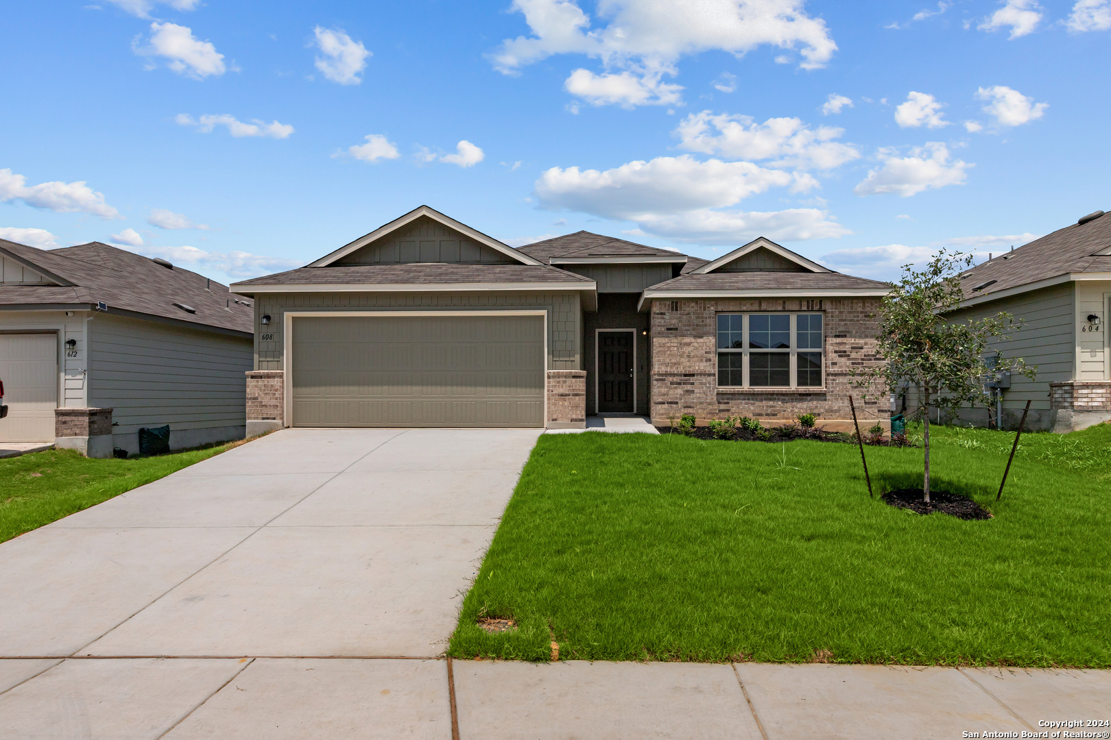 a front view of a house with a yard and garage