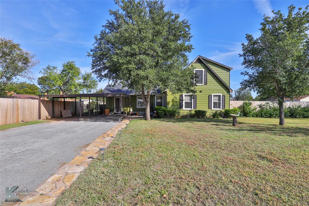 a view of a house with a yard and pathway