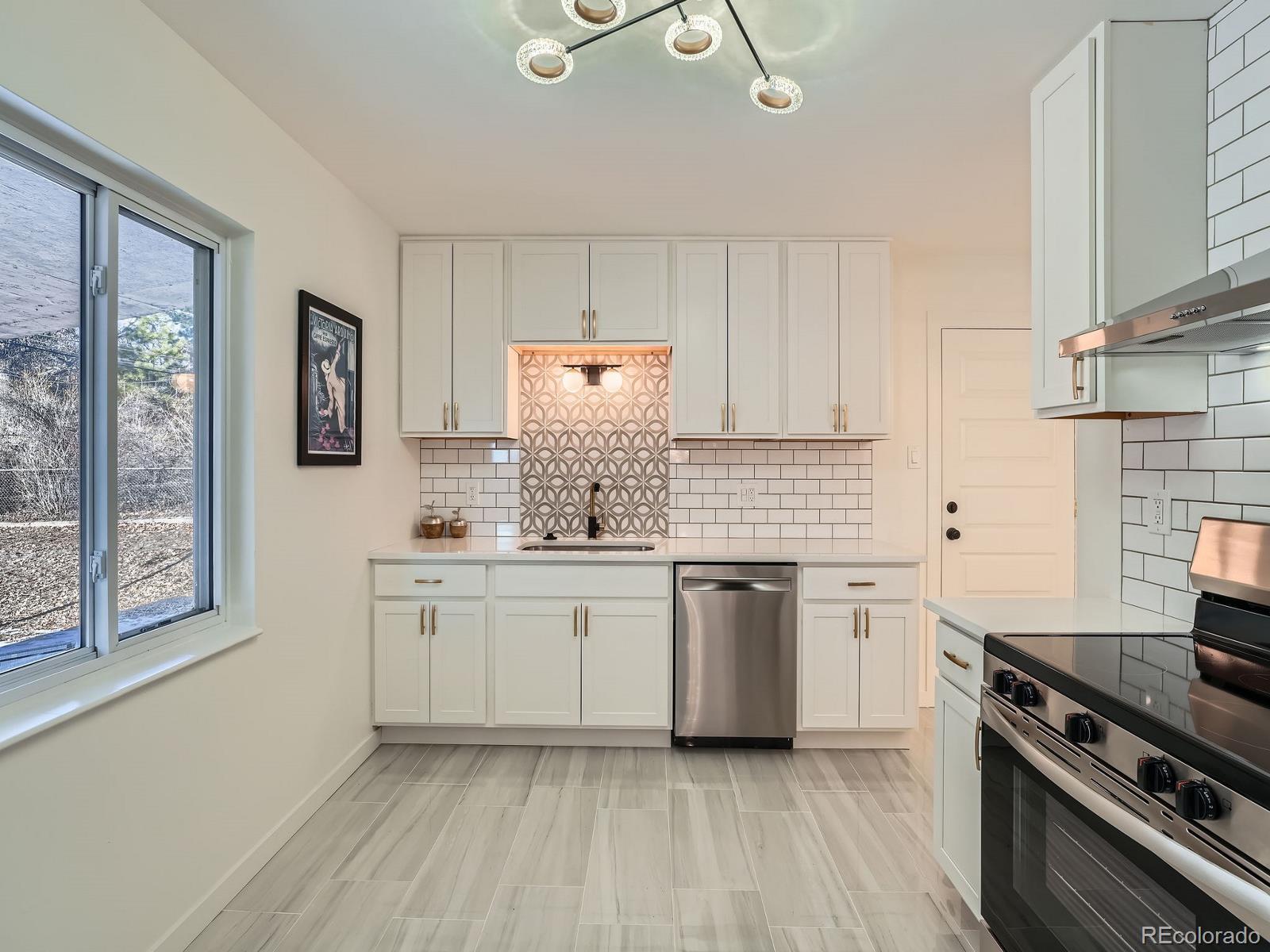 a kitchen with granite countertop cabinets stainless steel appliances a sink and a window