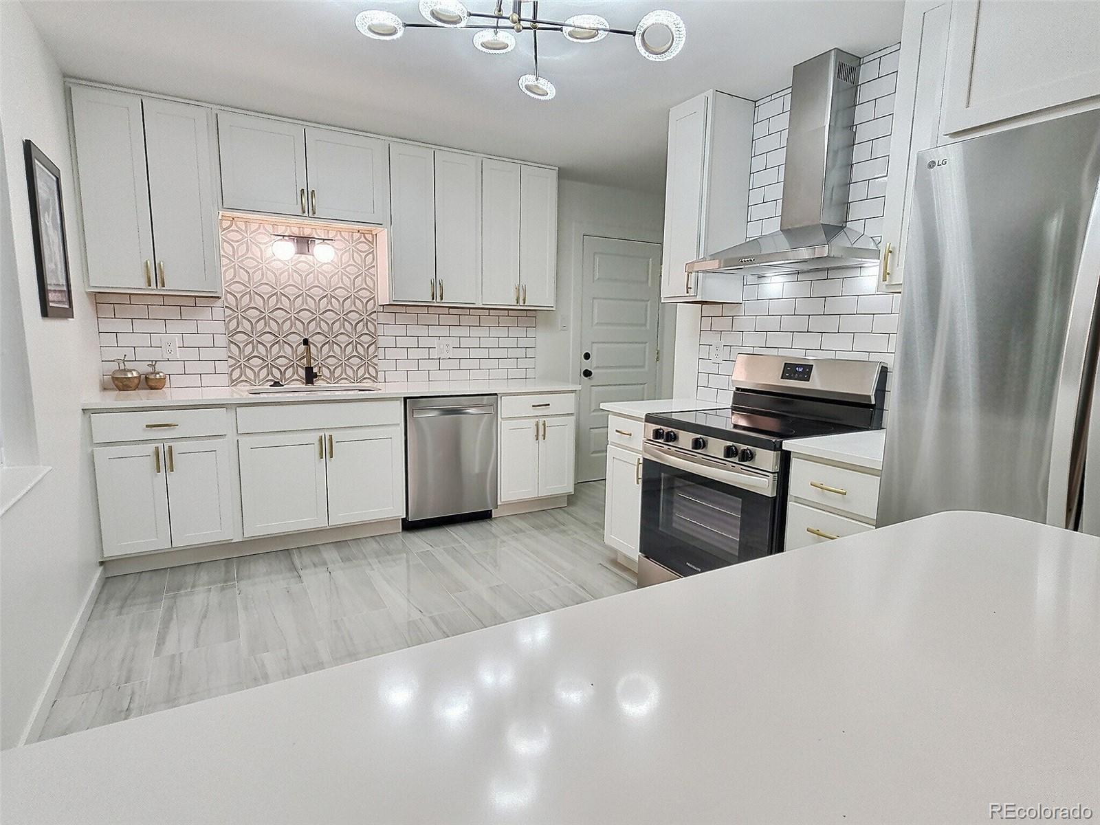 a kitchen with granite countertop a sink stainless steel appliances and cabinets