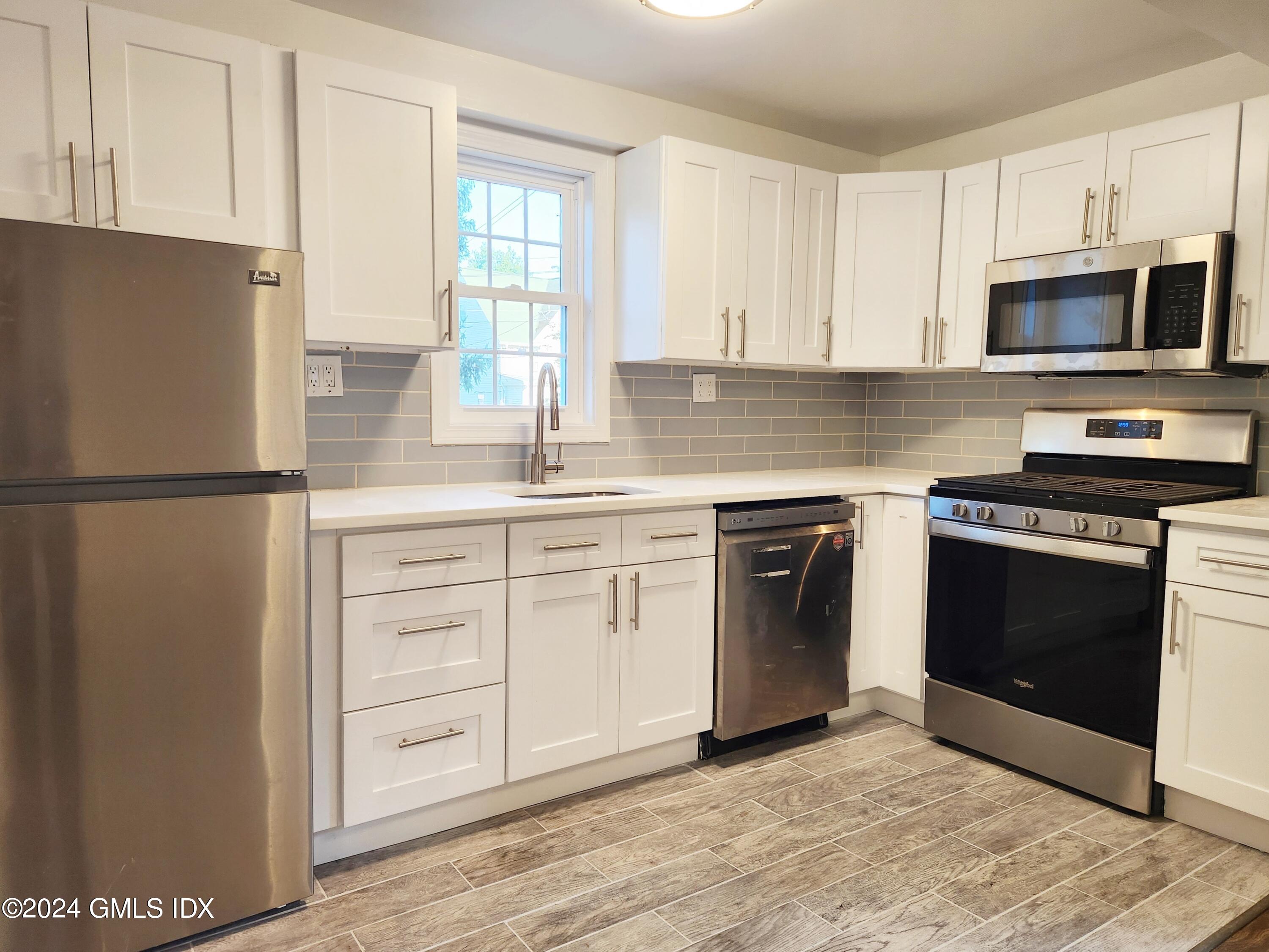 a kitchen with white cabinets and stainless steel appliances