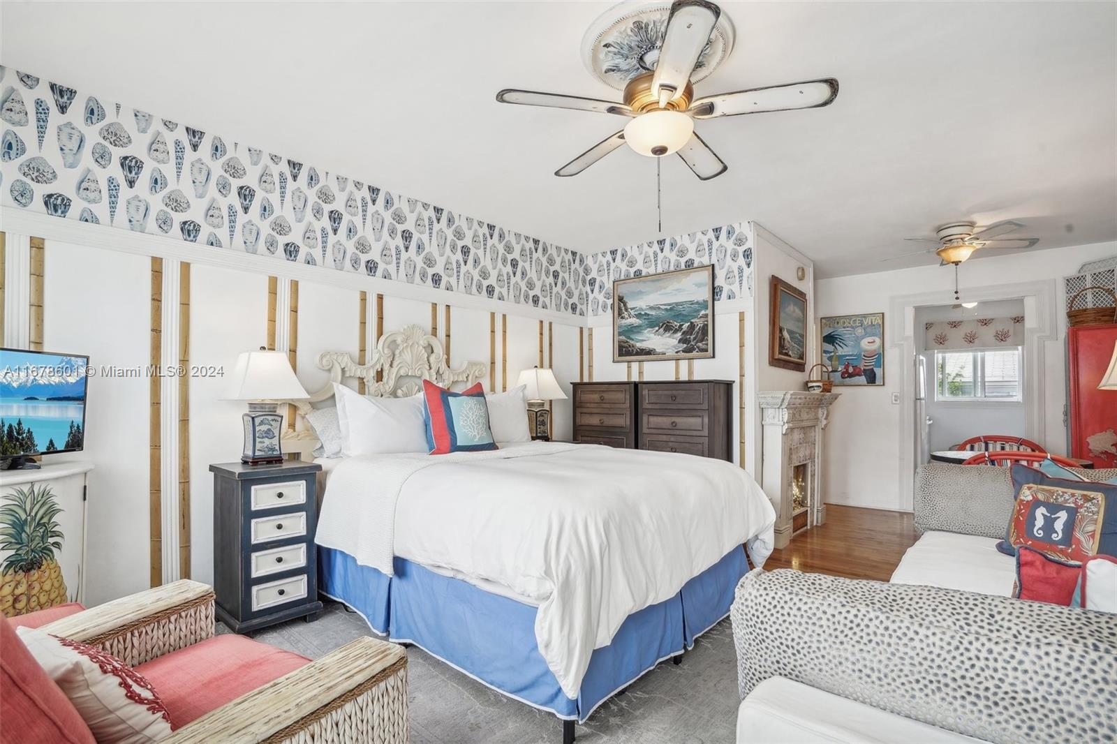 a bedroom with a bed ceiling fan and a wooden floor