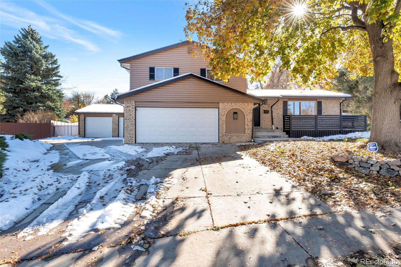 a front view of a house with a yard covered in snow