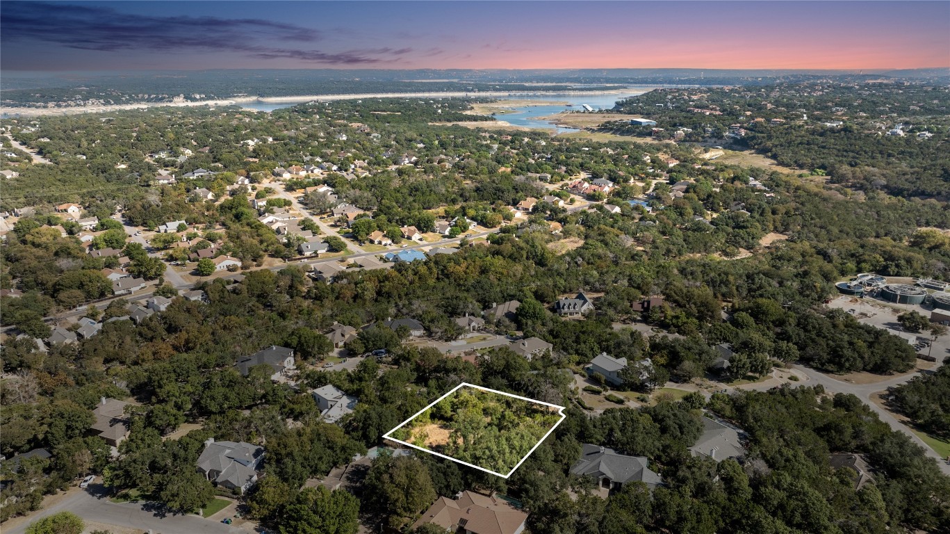 an aerial view of residential houses with outdoor space and trees