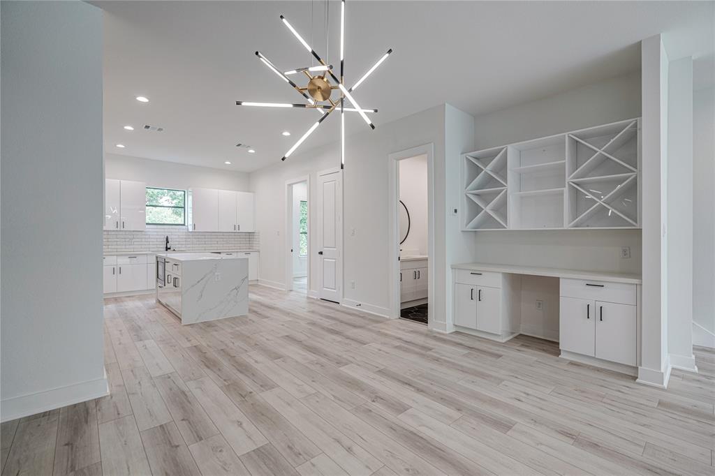 a view of a livingroom with a fireplace a ceiling fan and wooden floor