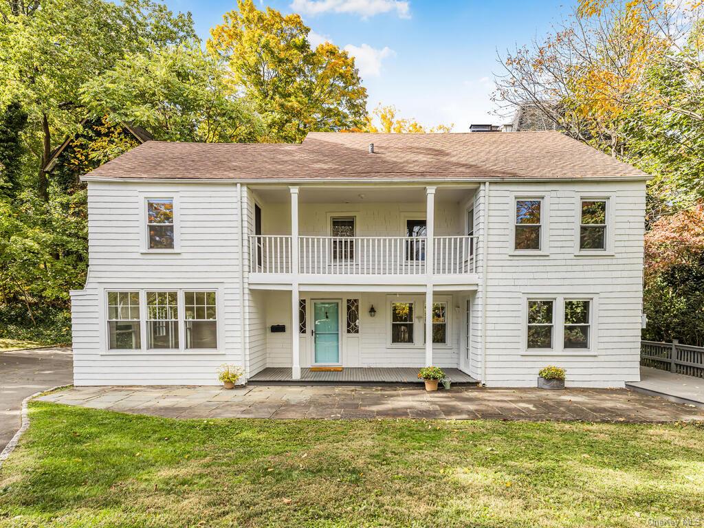 View of front facade featuring a front yard and a balcony