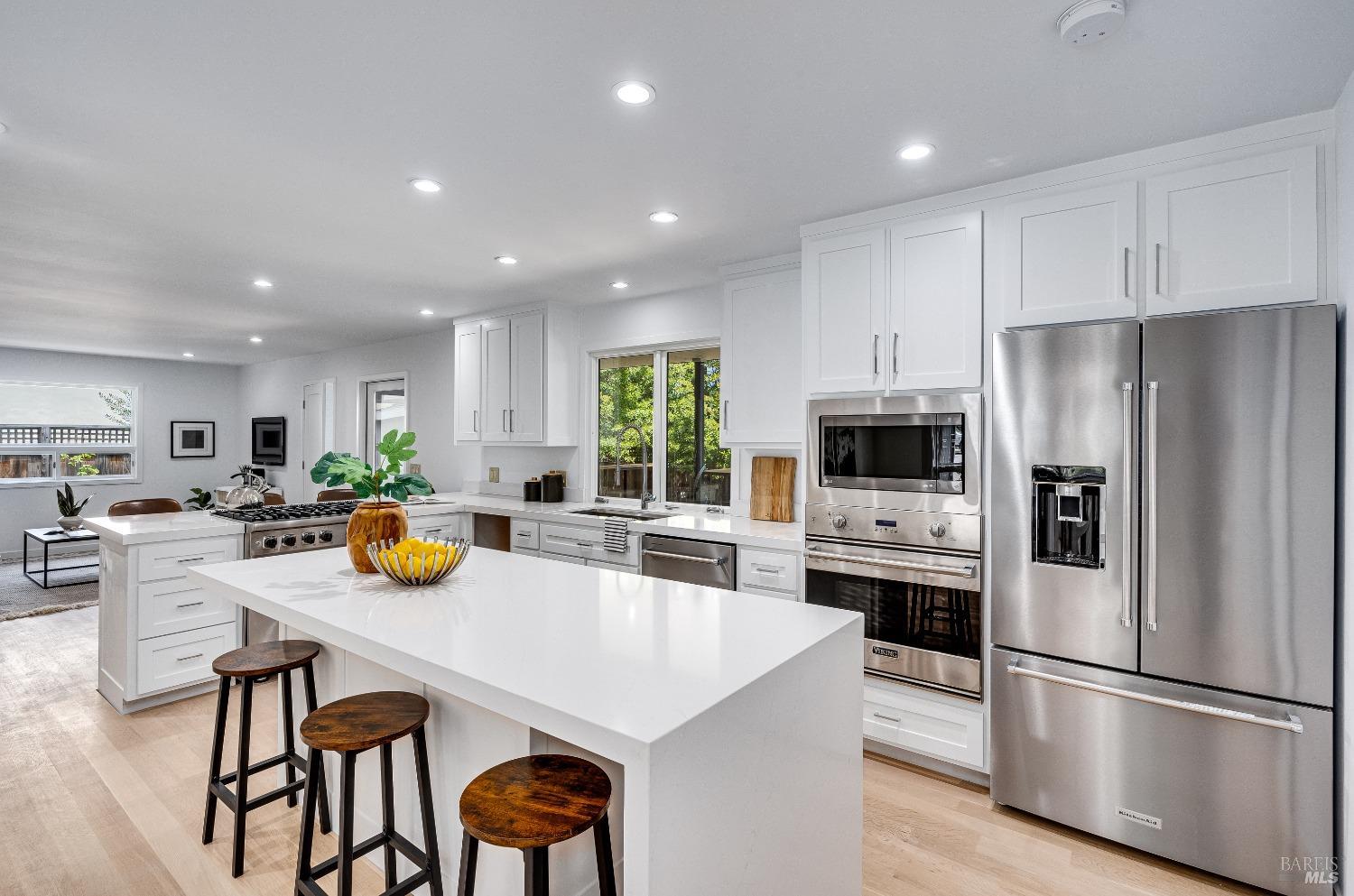 a kitchen with a sink a stove a refrigerator and white cabinets