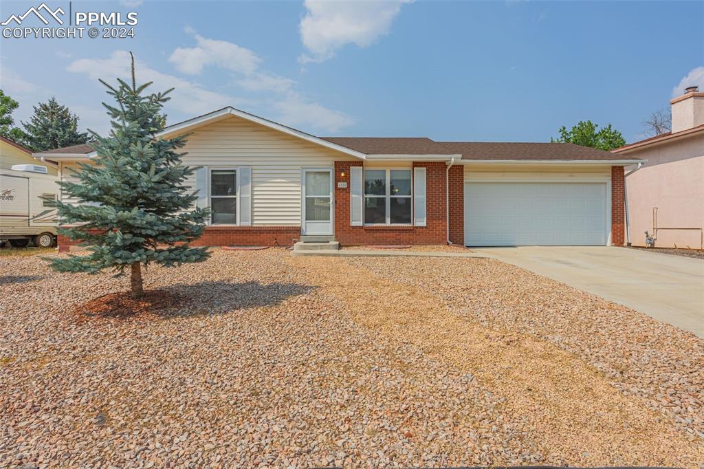 a front view of house with yard and trees around