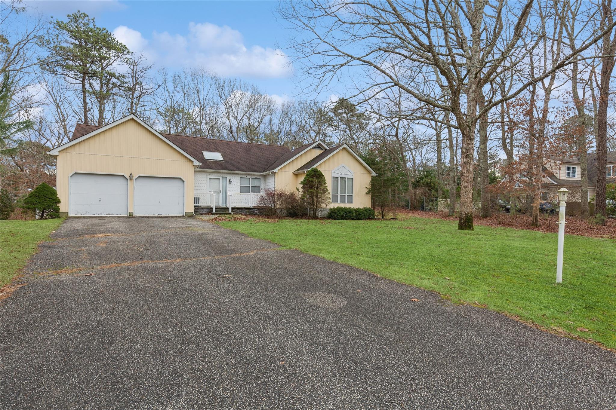 Ranch-style house with a front yard and a garage