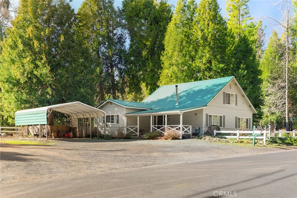 a front view of a house with a garden and trees